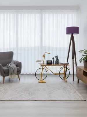 Modern bir yaşam alanında, tavandan yere kadar uzanan, krem tonunda, düz dökümlü, ferah, aydınlık ve huzurlu bir atmosfer yaratan şık tül perde.