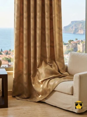 "Bolivya bronz sarı spor desenli dökümlü jakar fon perdenin dokulu mat-ışıltılı yüzeyinin ve sıcak pirinç tonunun modern bir salonda yarattığı rafine, ferah ve lüks atmosfer."