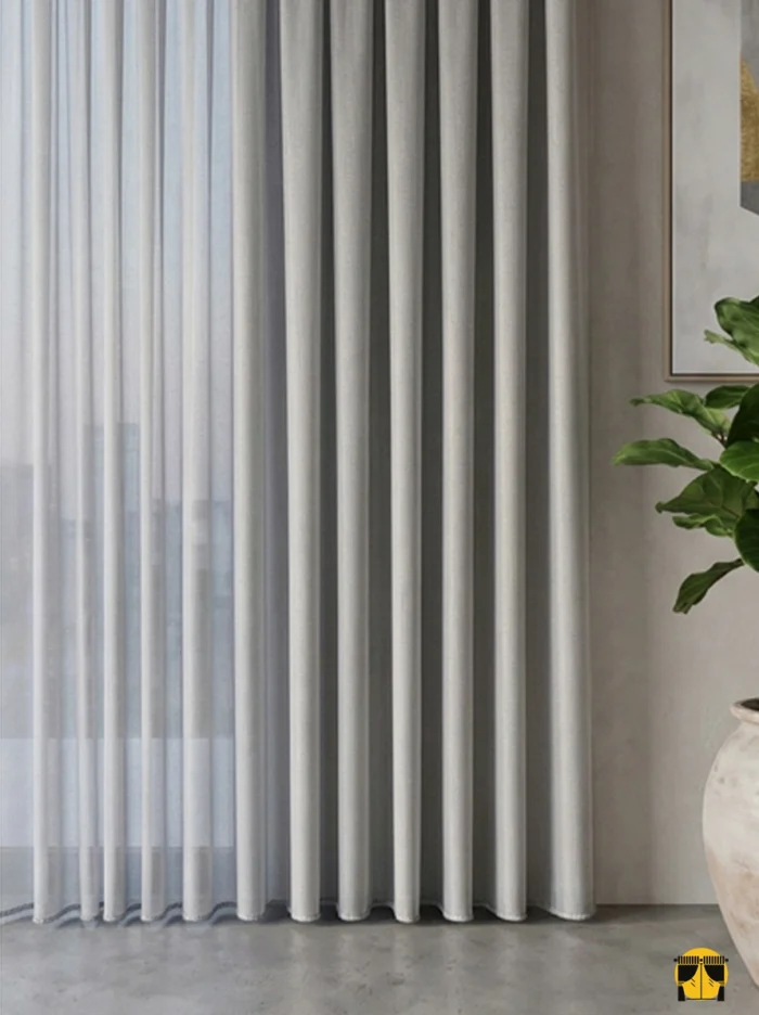 Kontrast ve Stil: "Vizon fon perdelerle kombinlenmiş, dökümlü yapısı sayesinde birer mimari sütun gibi muntazam inen sütlü kahve düz tül perde sergisi."