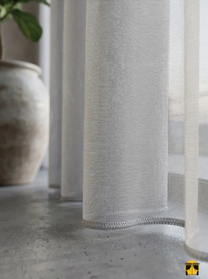 Doku Detayı: "Düz dokuma teknolojisiyle üretilmiş sütlü kahve tonundaki pürüzsüz yüzeyi ve kaliteli lif yapısını sergileyen yakın plan çekimi; pencereler için modern ve dökümlü tül perde karakteri."