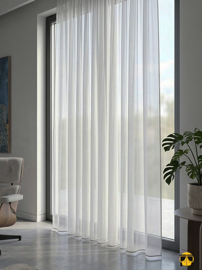 Işık ve Atmosfer: "İlyada açık gri keten tül perdenin doğal lifleri arasından süzülen güneş ışığının, oda içerisinde yarattığı modern, puslu ve karizmatik aydınlık."