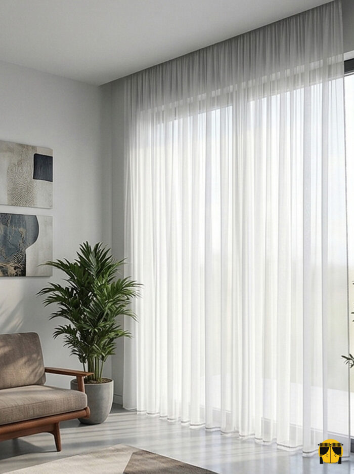 Mekan Tasarımı: "Antrasit fon perdeler ve metalik aksesuarlarla dekore edilmiş loft bir salonda, pencerelere mimari bir derinlik katan açık gri keten tül perde tasarımı."