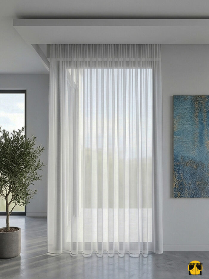 Kontrast ve Stil: "Beyaz duvarlar üzerinde asil bir kontrast oluşturan, dökümlü yapısı ve gümüşi tonuyla her tarza uyum sağlayan kaliteli açık gri keten tül sergisi."