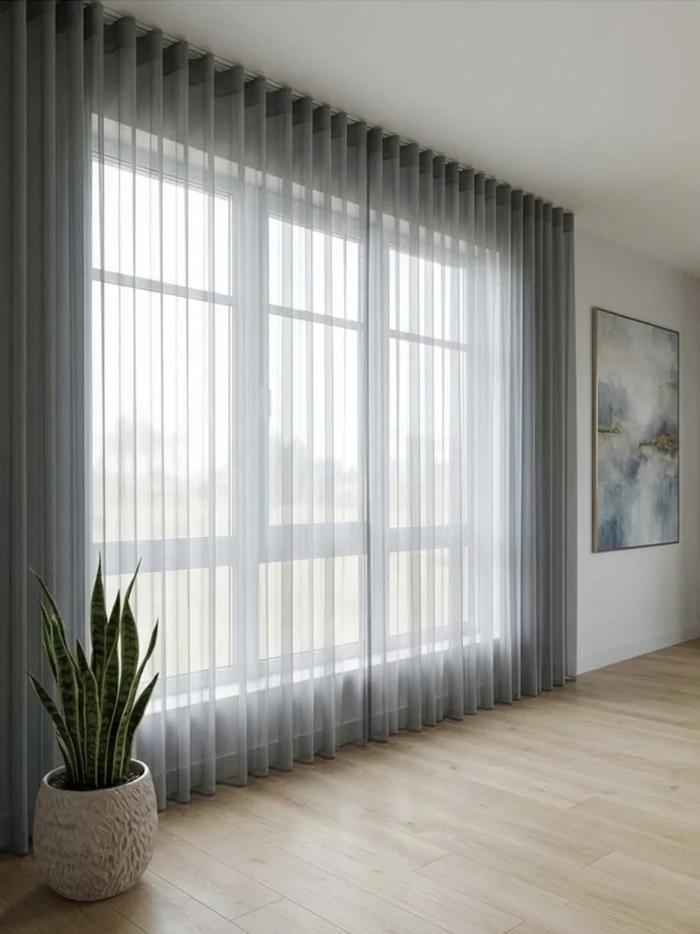 Kontrast ve Stil: "Beyaz duvarlar üzerinde asil bir kontrast oluşturan, dökümlü yapısı ve gümüşi tonuyla her tarza uyum sağlayan kaliteli gri keten tül sergisi."