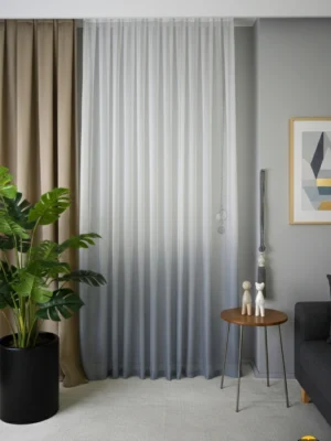 Tavandan yere kadar uzanan, yukarıdan aşağıya doğru beyazdan koyu griye yumuşak bir geçiş (degrade) yapan, modern ve şık tül perde.