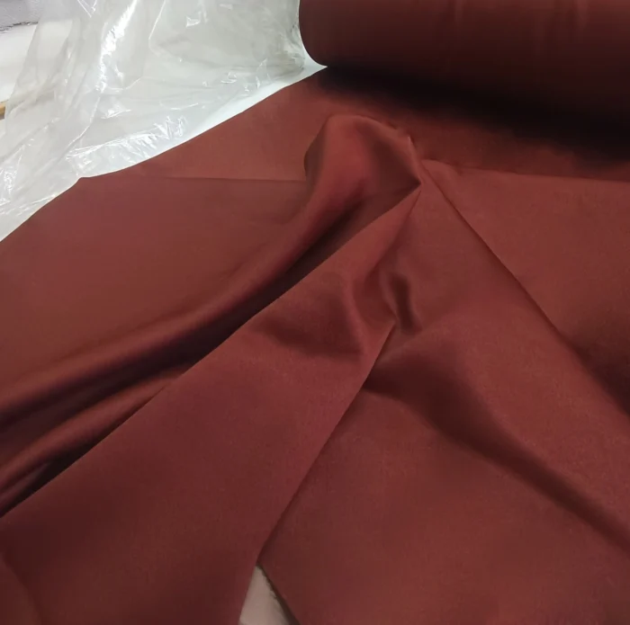 "Mat siyah metal rüstik borulara asılmış, modern panel duruşu sergileyen kaliteli kiremit rengi ışık geçirmez fon perde modeli."
