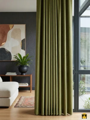 "Gri mobilyalar ve beyaz tüllerle kombinlenmiş, pencerelerde enerjik bir kontrast oluşturan dökümlü fıstık yeşili karartma perde uygulaması."