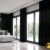 "Beyaz duvarlar ve gümüş gri tüllerle uyumlu, pencerelerde modern bir sanat galerisi etkisi oluşturan siyah hasır keten fon perde."