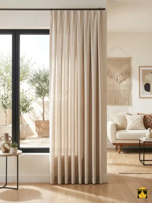 Ahşap mobilyalar ve jüt halılarla kusursuz bir uyum yakalayan, mat yüzeyi ve belirgin lifleriyle pencerelere derinlik katan koyu bej tül perde