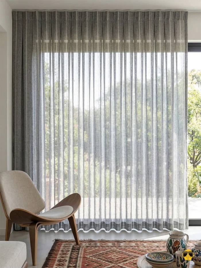 Işığı çizgisel bir formla dağıtarak mahremiyet sağlayan, ütü gerektirmeyen ve modern minimalizmi yansıtan şık Tendo gri tül sergisi.