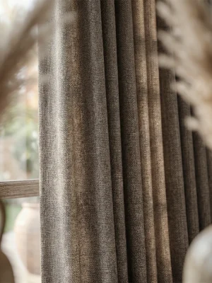 Duruş ve Estetik: "Ağır dökümü sayesinde rüzgarda formunu bozmayan, ütü gerektirmeyen ve modern bir zarafet sunan kaliteli kahve keten fon perde detayı."