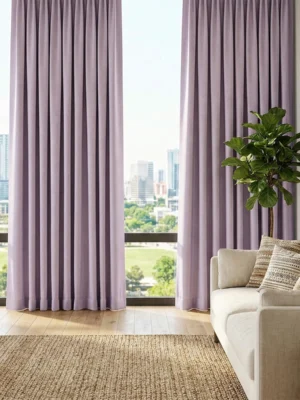 Beyaz ve gri tonlarla dekore edilmiş bir salonda, pencerelere romantik ve modern bir derinlik kazandıran mat yüzeyli lila fon perde detayı