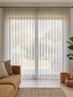 Modern bir salonda, antrasit fon perdelerle kombinlenmiş, pencerelere derinlik ve ipeksi bir asalet katan taş gri tül perde tasarımı