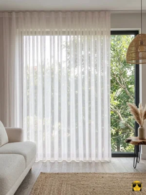 Modern bir yatak odasında, tavandan yere kadar sütun gibi dökülen kalın dokulu toz pembe tül perdenin mekana kattığı yumuşak derinlik