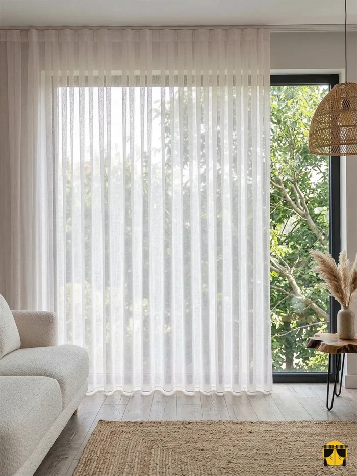 Modern bir yatak odasında, tavandan yere kadar sütun gibi dökülen kalın dokulu toz pembe tül perdenin mekana kattığı yumuşak derinlik