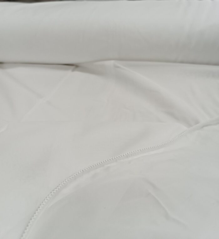 Güneş ışığı altında inci beyazı yansımalar sunan, ince ve ipeksi dokulu özel dikim ekru tül perde.