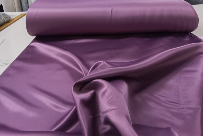 Kampanyalı fiyatlarla sunulan, pürüzsüz yüzeyli ve dökümlü mürdüm moru saten fon perde uygulaması.