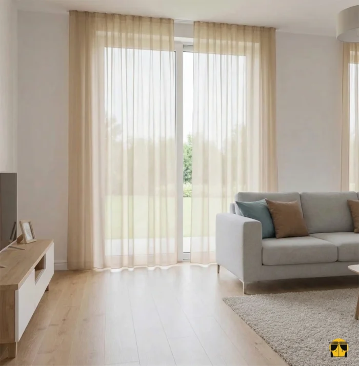 Pella düz hardal sarı tül perdenin pürüzsüz dokusu arasından süzülen ışığın, oda içerisinde yarattığı sıcak, amber tonlarında ve huzurlu aydınlık