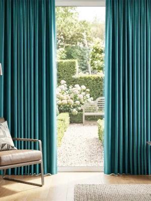 Ağır dökümü sayesinde rüzgarla birlikte zarifçe süzülen, ütü sonrası pürüzsüzlüğüyle ayna etkisi yaratan kaliteli turkuaz mavi saten perde detayı