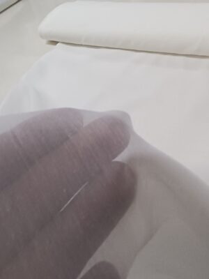 Pencereden süzülen güneş ışığı altında yarı şeffaf yapısıyla ferah bir atmosfer yaratan düz ekru tül.