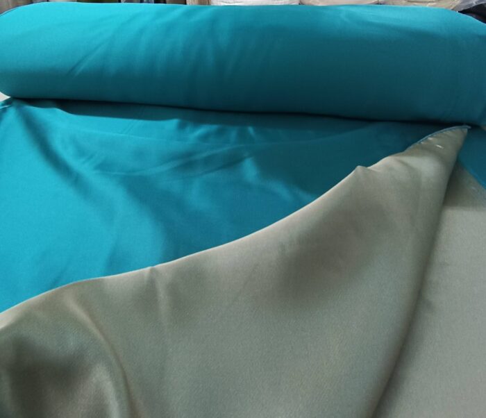 Modern salonlarda gri ve beyaz mobilyalarla mükemmel bir kontrast oluşturan dökümlü turkuaz saten fon perde.