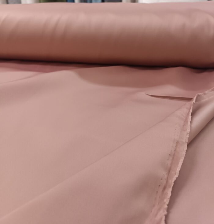 Yüksek kaliteli saten dokuma kumaşın dökümlü yapısını ve yavruağzı tonunu gösteren yakın çekim görseli.