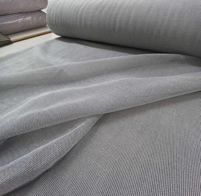 Salda açık gri keten tül perdenin nefes alan gözenekli kumaş dokusu.