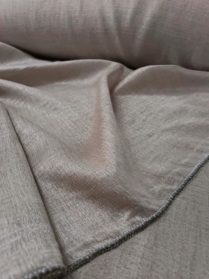 Geniş pencerelerde dökümlü duran ağır gramajlı bej parlak tül.