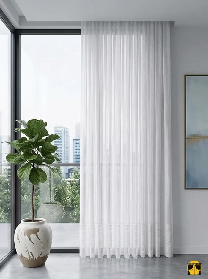 Kontrast ve Stil: "Antrasit fon perdelerle kombinlenmiş, ağır dökümü sayesinde sütun gibi inen, ütü istemeyen kaliteli eteği desenli tül sergisi."