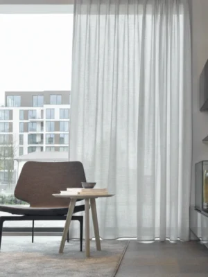 Modern bir salonda antrasit koltuklarla kombinlenmiş kalın dokulu gri tül perde.