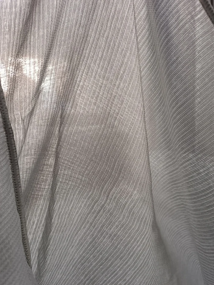 Loft tipi bir dairede boydan boya camlara uygulanmış dökümlü gri tül görünümü