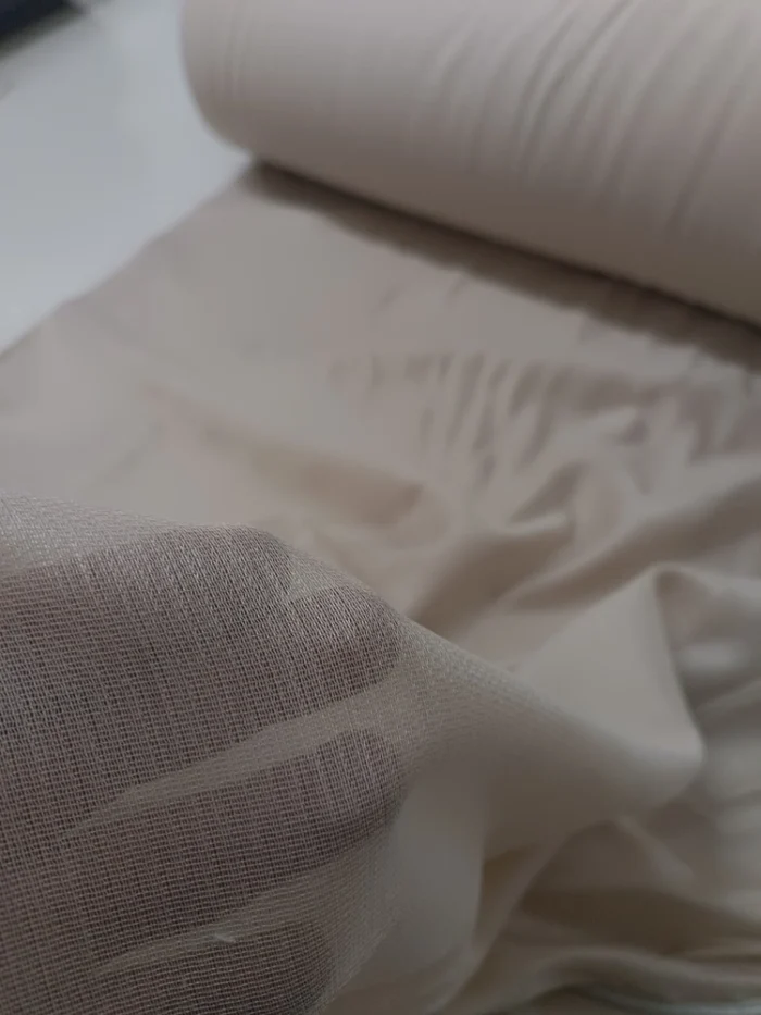 Yatak odasında huzurlu bir atmosfer yaratan, ışık geçiren yumuşak dokulu bej düz tül perde görünümü