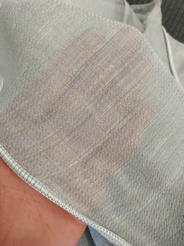 Antrasit dolaplar ve mermer tezgahla uyum sağlayan, dökümlü yapısı sayesinde mutfağa ferah bir derinlik katan açık gri keten tül perde tasarımı