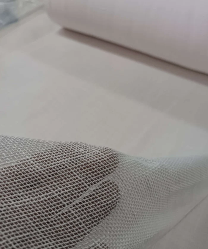 Beyaz mutfak dolapları ve ahşap detaylarla dekore edilmiş modern bir mutfakta, pencerelere ferahlık ve naif bir derinlik katan açık pembe kalın keten tül perde tasarımı