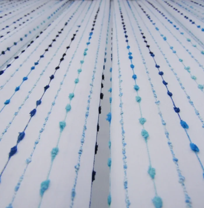 Işık ve Atmosfer: "Mavi ponponlu çizgili mutfak tül perdesinin dokusu arasından süzülen güneş ışığının, mutfakta yarattığı ferah, neşeli ve modern aydınlık."