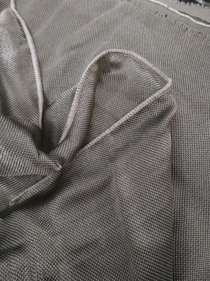 "Beyaz mutfak dolapları önünde asil bir kontrast oluşturan, gün ışığını füme bir filtreyle içeri alan kaliteli dökümlü koyu gri tül perde sergisi