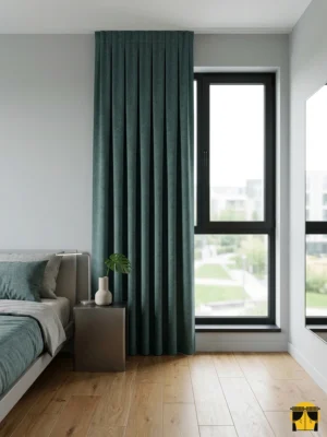 "Gümüş gri tüllerle kombinlenmiş, ağır dökümü sayesinde mimari bir sütun gibi duran petrol mavisi keten fon perde uygulaması."