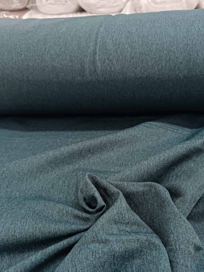 "Geniş balkon pencerelerinde tavandan yere kadar uzanan, odayı daha yüksek ve huzurlu gösteren sık pileli petrol mavisi fon perde tasarımı."