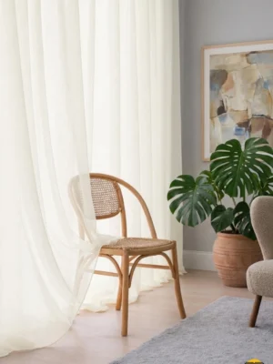 "Lapaz krem keten tül perdenin ilmek detaylı dokusu arasından süzülen güneş ışığının, oda içerisinde yarattığı rüstik ve ferah aydınlık."