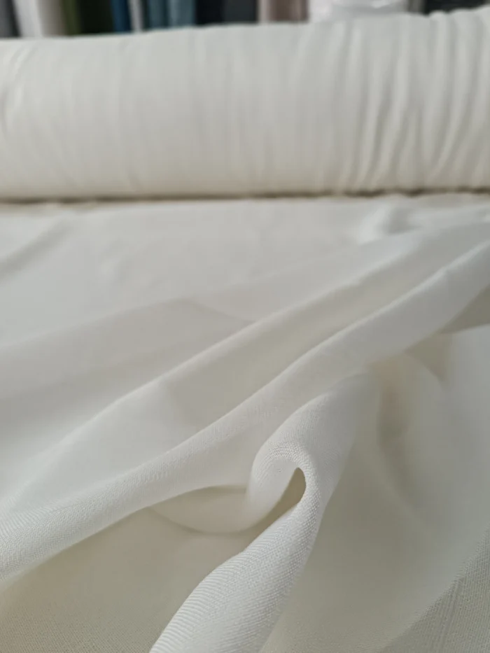 "Kahverengi fon perdelerle kombinlenmiş, ilmekli yapısı sayesinde pencerelerde zengin bir duruş sergileyen krem keten tül perde uygulaması."