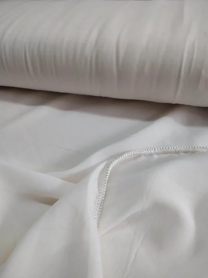 "Krep dokuma teknolojisiyle üretilmiş bej tonundaki pütürlü yüzeyi ve tok lif yapısını sergileyen mutfak perdesi yakın plan çekimi."