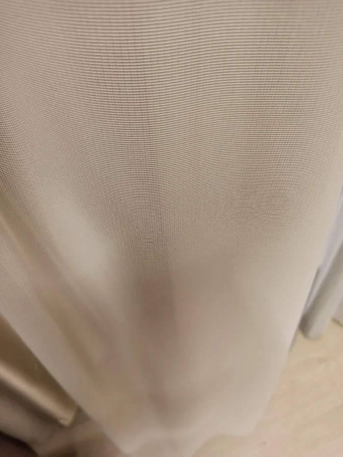 "Düz dokuma teknolojisiyle üretilmiş kum beji tonundaki pürüzsüz yüzeyi ve dökümlü lif yapısını sergileyen Esento serisi mutfak perdesi yakın plan çekimi."