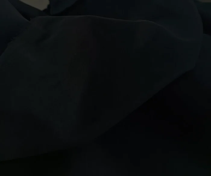 "Antrasit mobilyalar ve gri detaylarla dekore edilmiş endüstriyel bir yatak odasında, pencerelere asalet katan siyah düz fon perde."