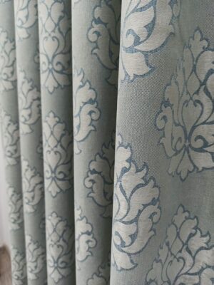 "Beyaz lake mobilyalar ve ekru tüllerle dekore edilmiş neoklasik bir yatak odasında, pencerelere asalet katan damask desenli perde."