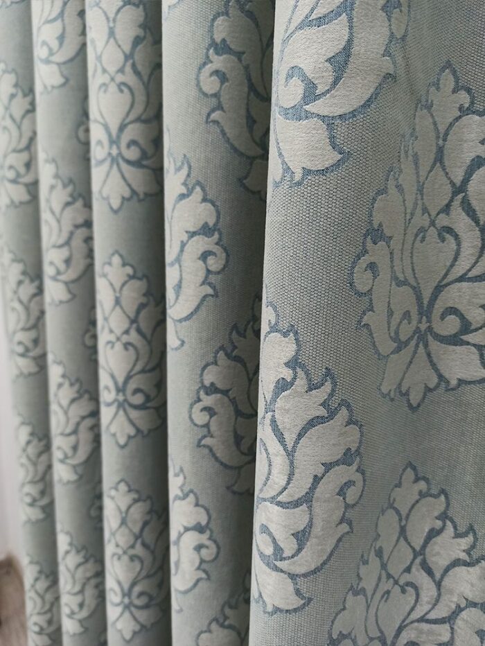 "Beyaz lake mobilyalar ve ekru tüllerle dekore edilmiş neoklasik bir yatak odasında, pencerelere asalet katan damask desenli perde."