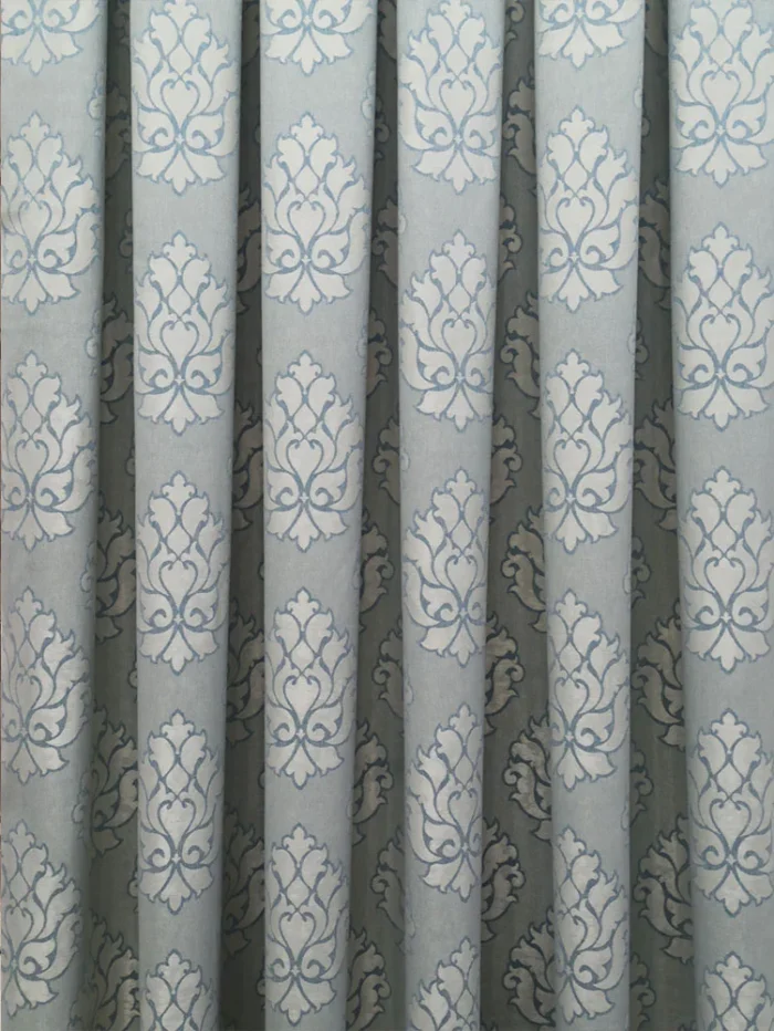 "Gümüş detaylarla kombinlenmiş, ağır dökümü sayesinde pencerelerde saray şıklığı sergileyen açık mavi yeşil fon perde uygulaması."