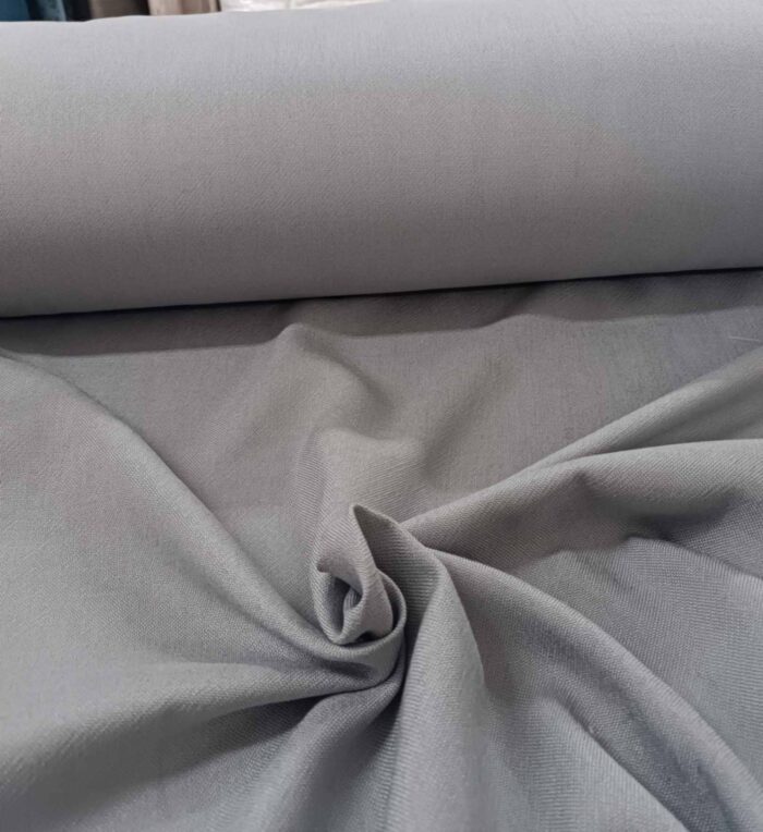 "Özel keten dokuma teknolojisiyle üretilmiş gümüş gri fon perde kumaşının mat yüzeyini ve doğal lif geçişlerini sergileyen yakın plan."