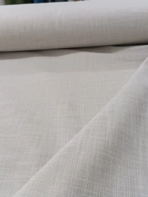 "Ahşap mobilyalar ve ekru tüllerle dekore edilmiş modern bir yatak odasında, pencerelere asalet katan Myra krem keten perde."