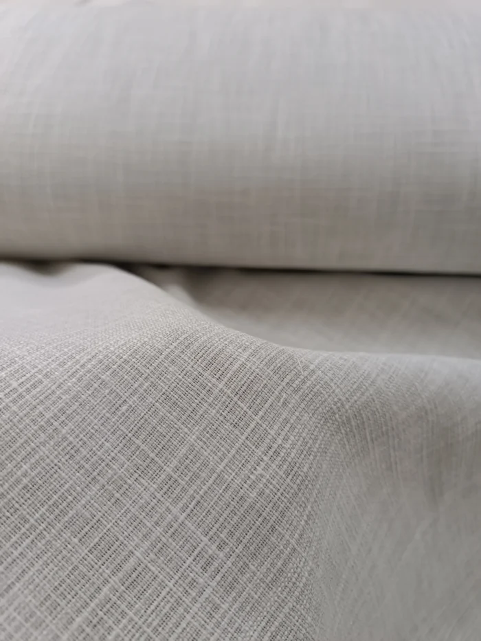 "Modern minimalist dekorasyon anlayışına uygun, gün ışığını yumuşakça filtreleyerek odayı geniş gösteren kaliteli krem keten perde görseli."