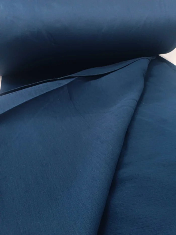 "Gümüş gri tüllerle kombinlenmiş, ağır dökümü sayesinde pencerelerde zengin bir duruş sergileyen lacivert kadife perde uygulaması."